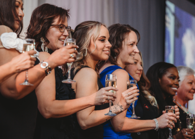 Women holding drinks at WOI 2025